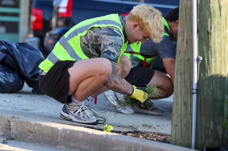 a man squatting on the sidewalk