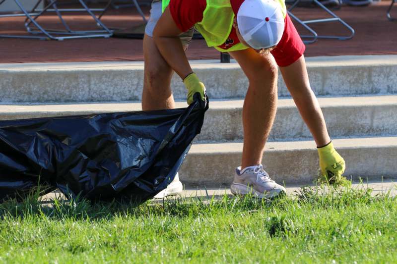 a person picking up trash from a bag