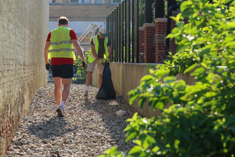 two men wearing reflective vests walking along a path