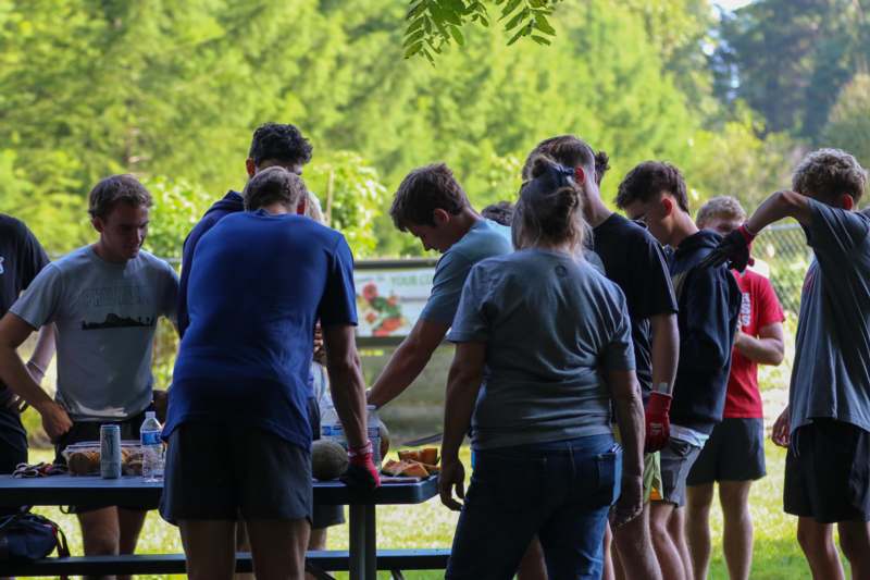 a group of people standing around a table