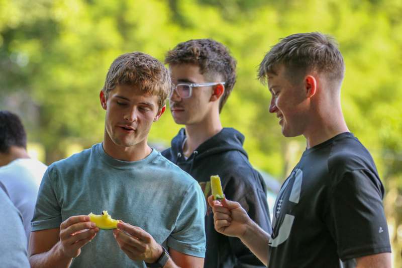 a group of young men eating fruit