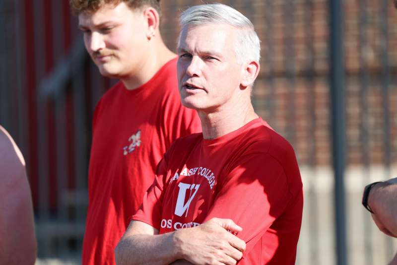 a man in red shirt with his arms crossed