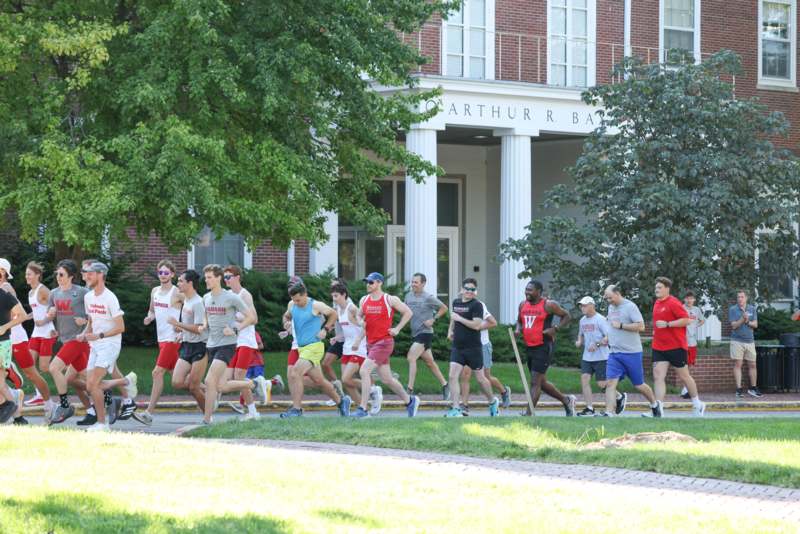 a group of people running on a sidewalk