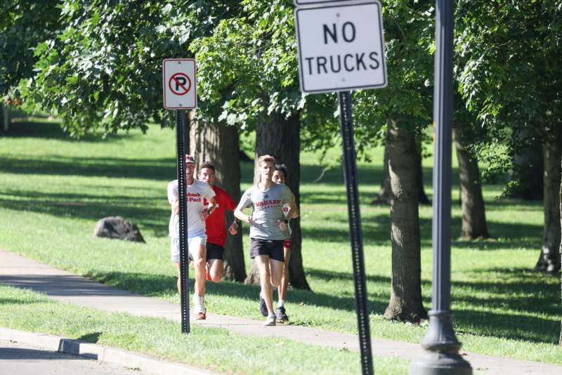 a group of people running on a sidewalk