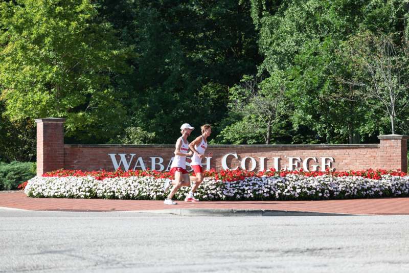 a group of people running in front of a sign