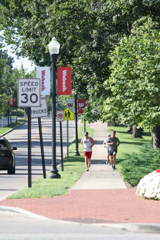 a group of people running on a sidewalk