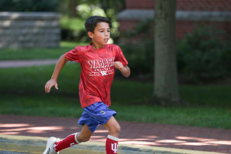 a boy running on a sidewalk