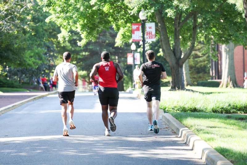 a group of men running on a road
