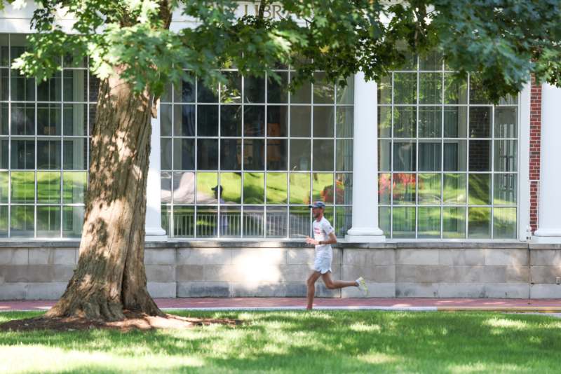a man running on grass near a tree