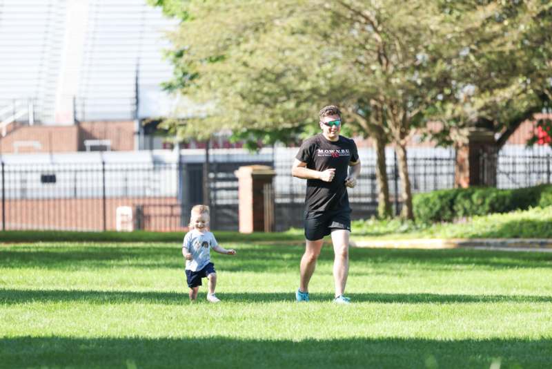 a man and child running in a park