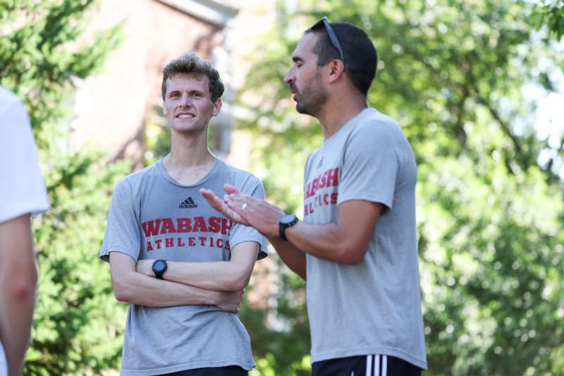 a man standing next to another man