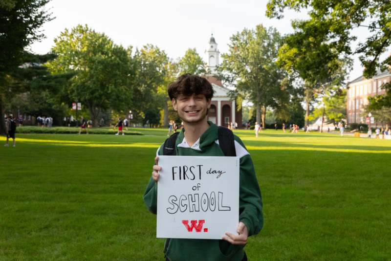 a man holding a sign in front of a building