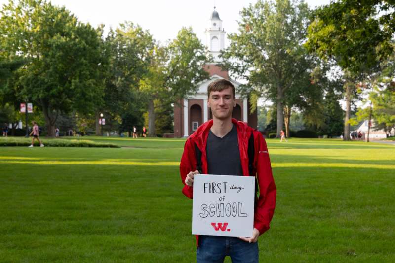 a man holding a sign in front of a building