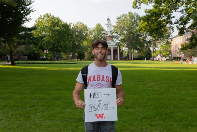 a man holding a sign in front of a building