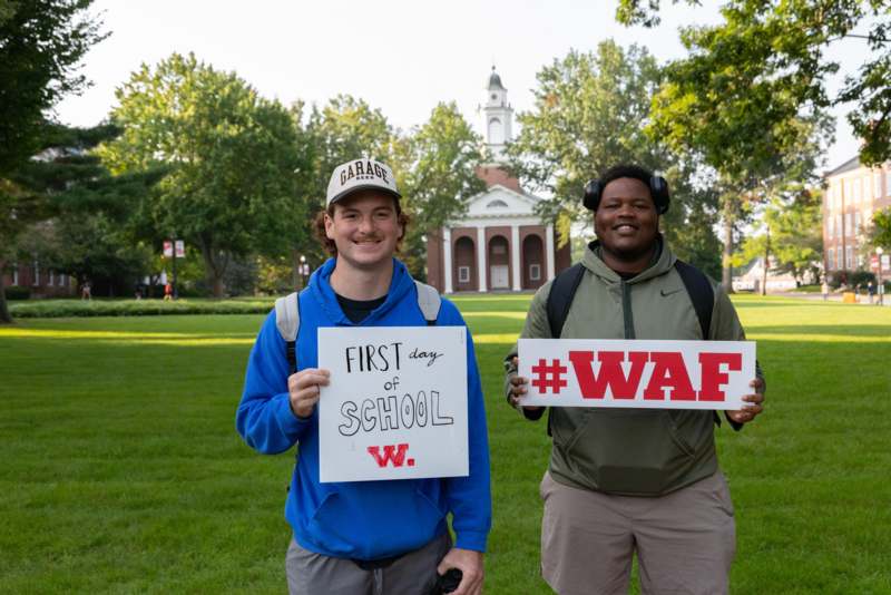 two men holding signs in front of a building