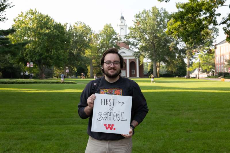 a man holding a sign in front of a building