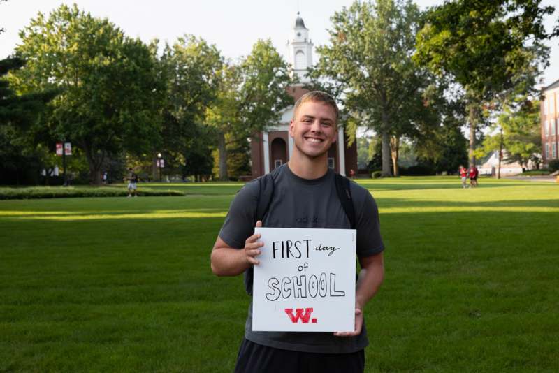 a man holding a sign in front of a building