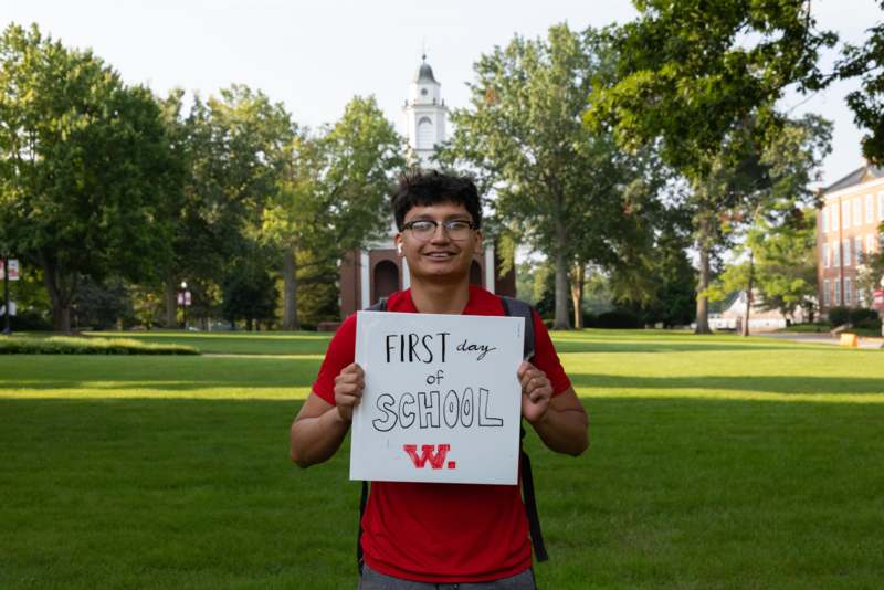 a man holding a sign in front of a building