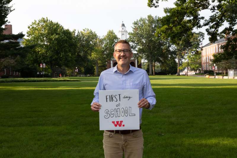 a man holding a sign in front of a building