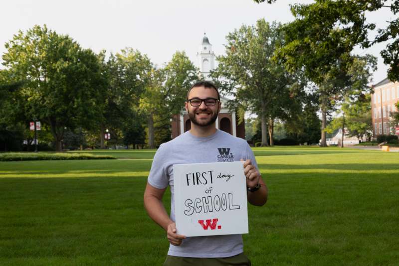 a man holding a sign in front of a building