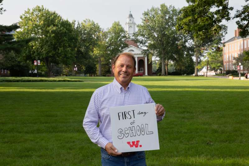 a man holding a sign in front of a building