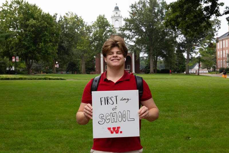 a man holding a sign in front of a building
