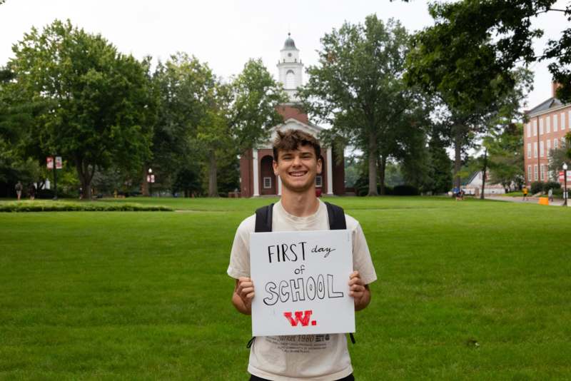 a man holding a sign in front of a building
