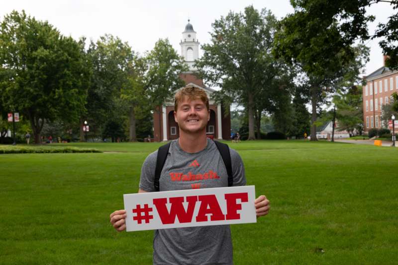 a man holding a sign in front of a building