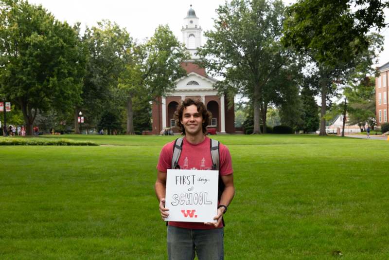 a man holding a sign in front of a building
