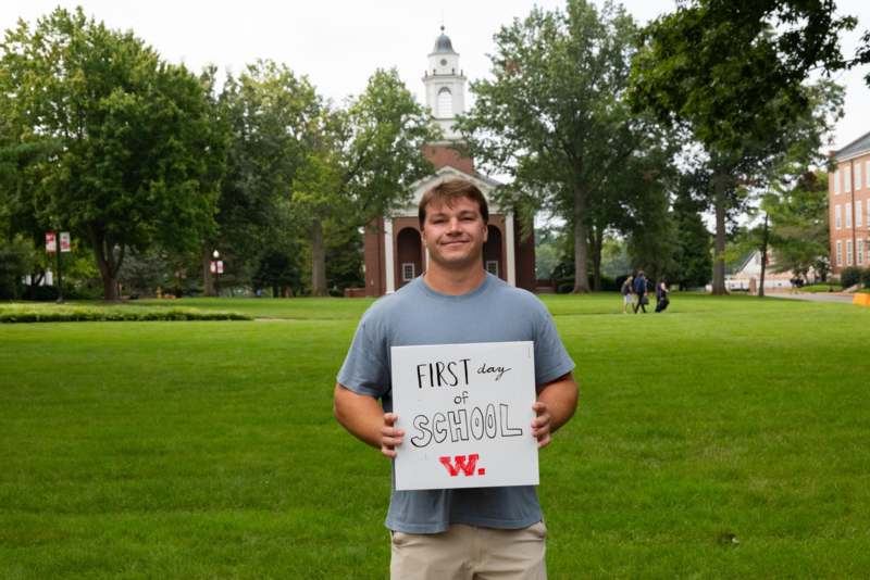 a man holding a sign in front of a building