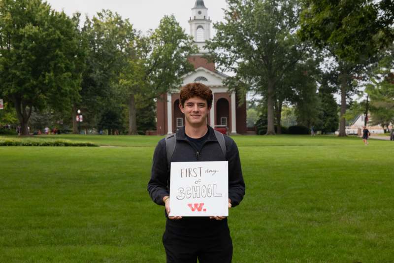 a man holding a sign in front of a building