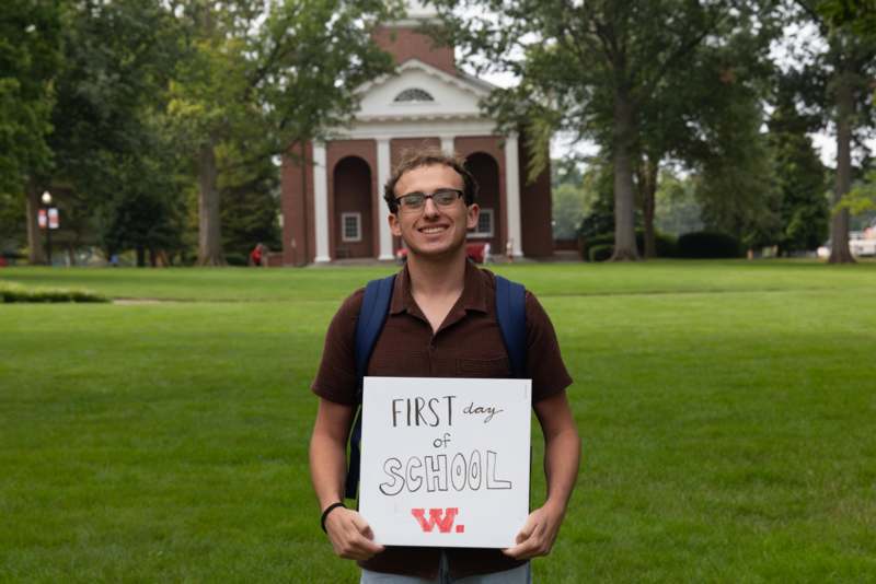 a man holding a sign in front of a building