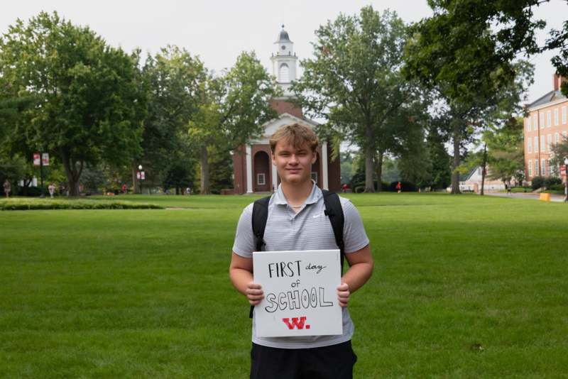 a man holding a sign in front of a building