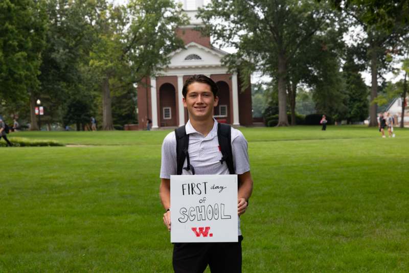 a man holding a sign in front of a building