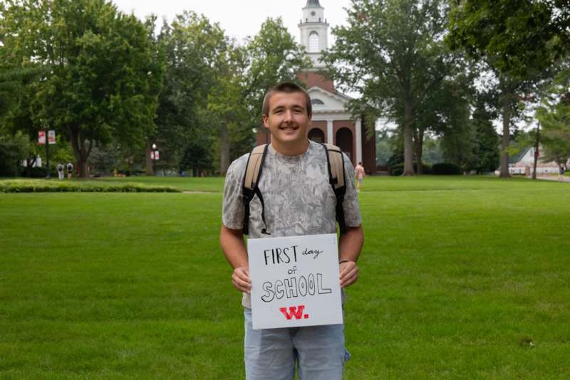 a man holding a sign in front of a building
