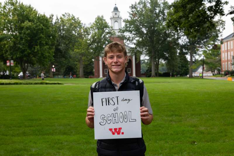 a man holding a sign in front of a building