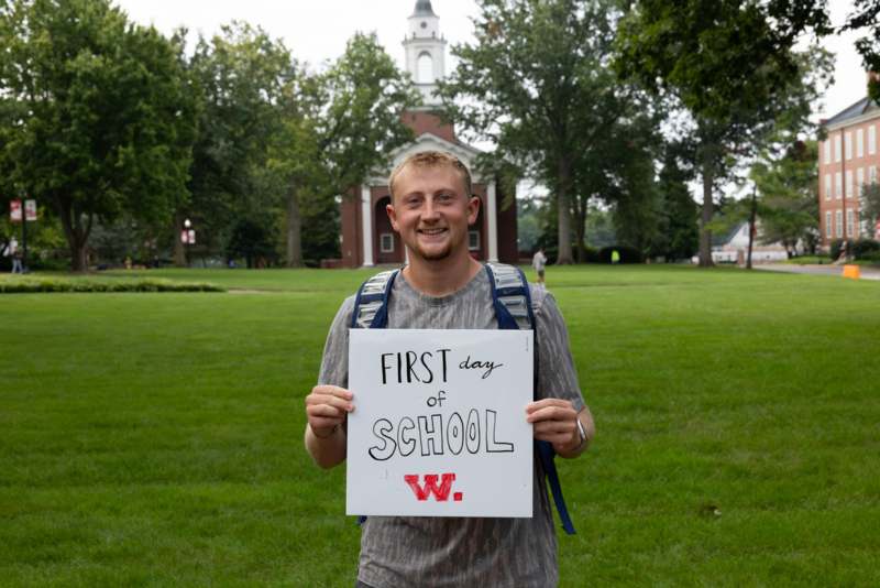 a man holding a sign in front of a building