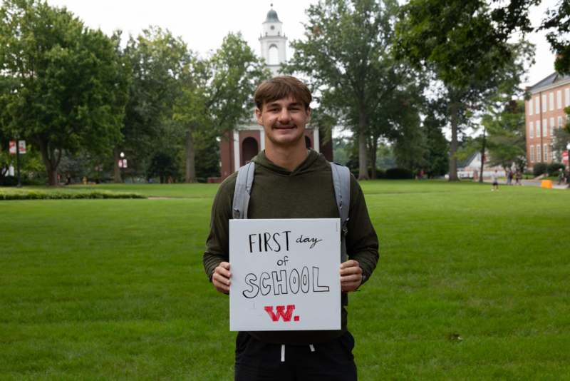 a man holding a sign in front of a building