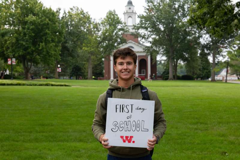 a man holding a sign in front of a building