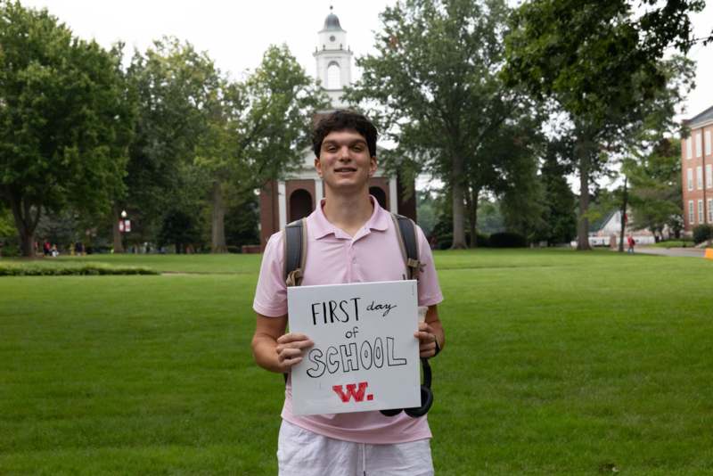 a man holding a sign in front of a building
