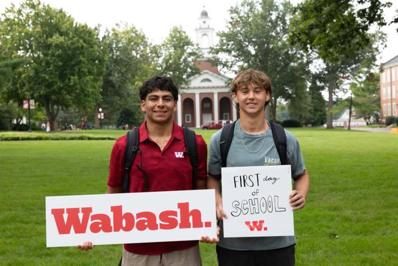 two men holding signs in front of a building