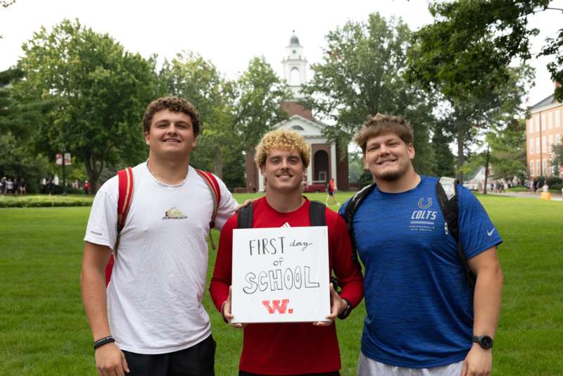 a group of men standing in a field holding a sign