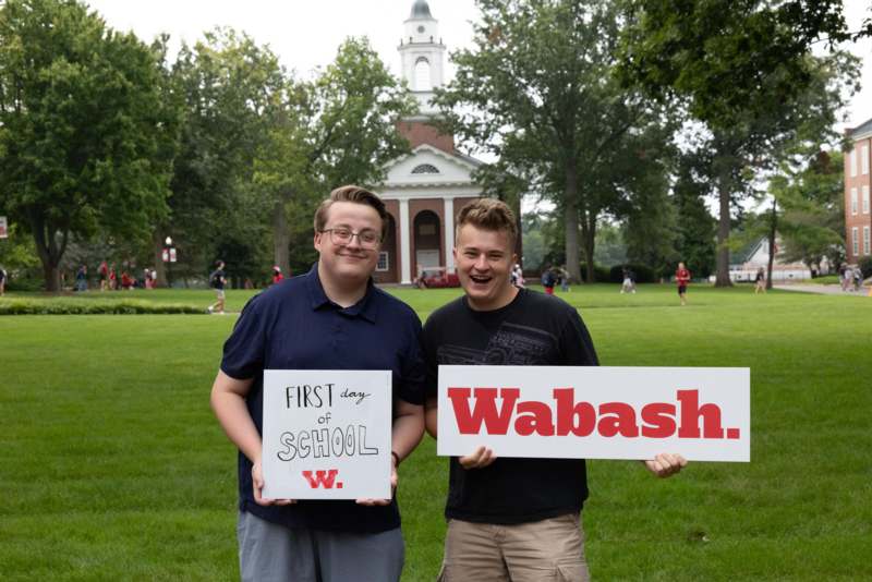 two men holding signs in front of a building