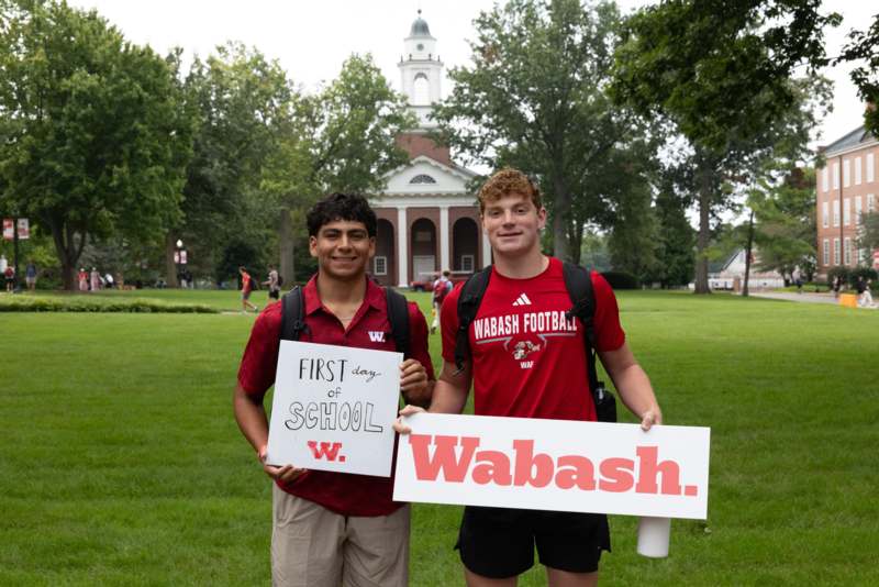 two men holding signs in front of a building