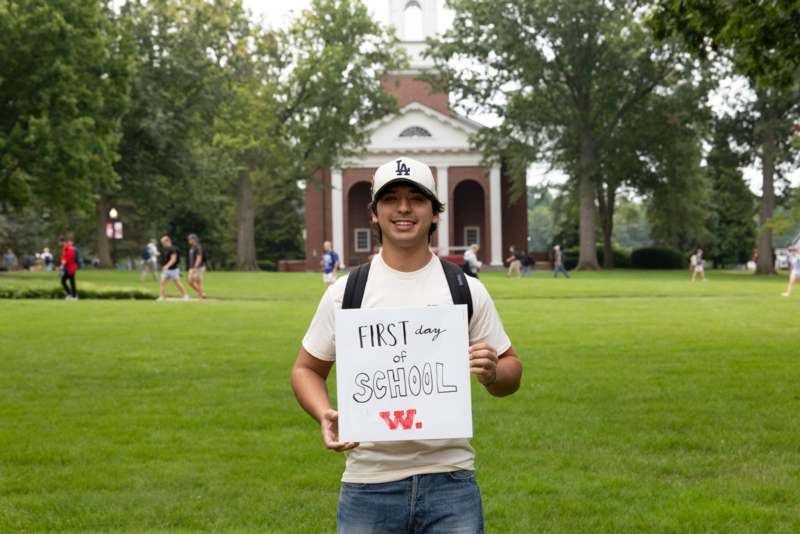 a man holding a sign in front of a building