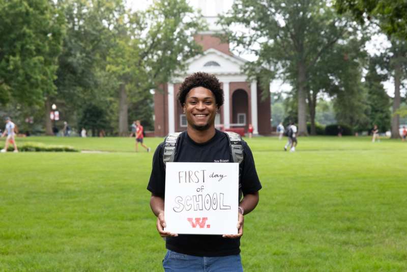 a man holding a sign in front of a building