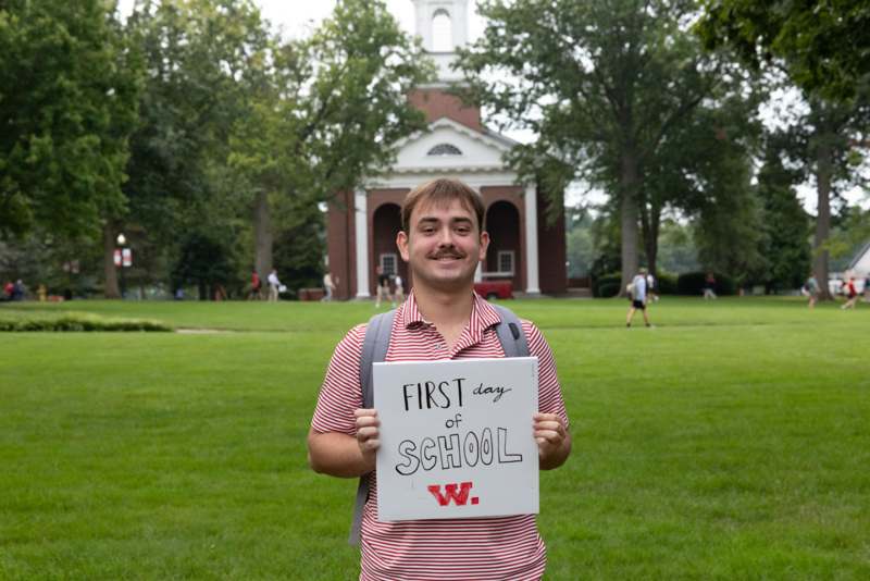 a man holding a sign in front of a building