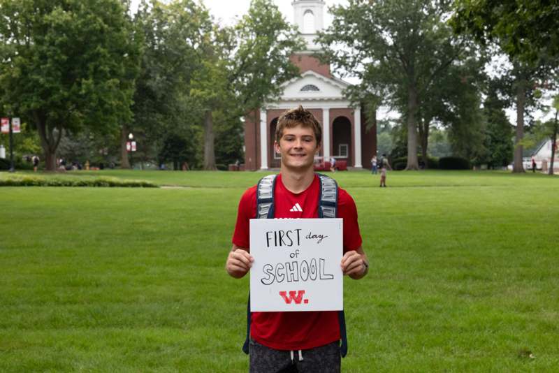 a man holding a sign in front of a building