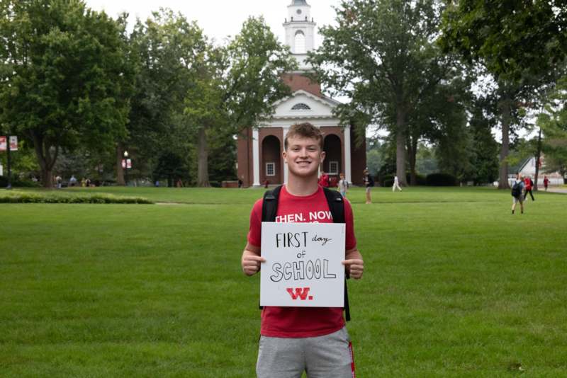 a man holding a sign in front of a building