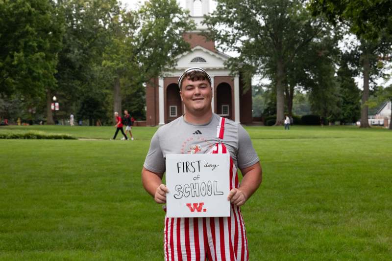 a man holding a sign in front of a building